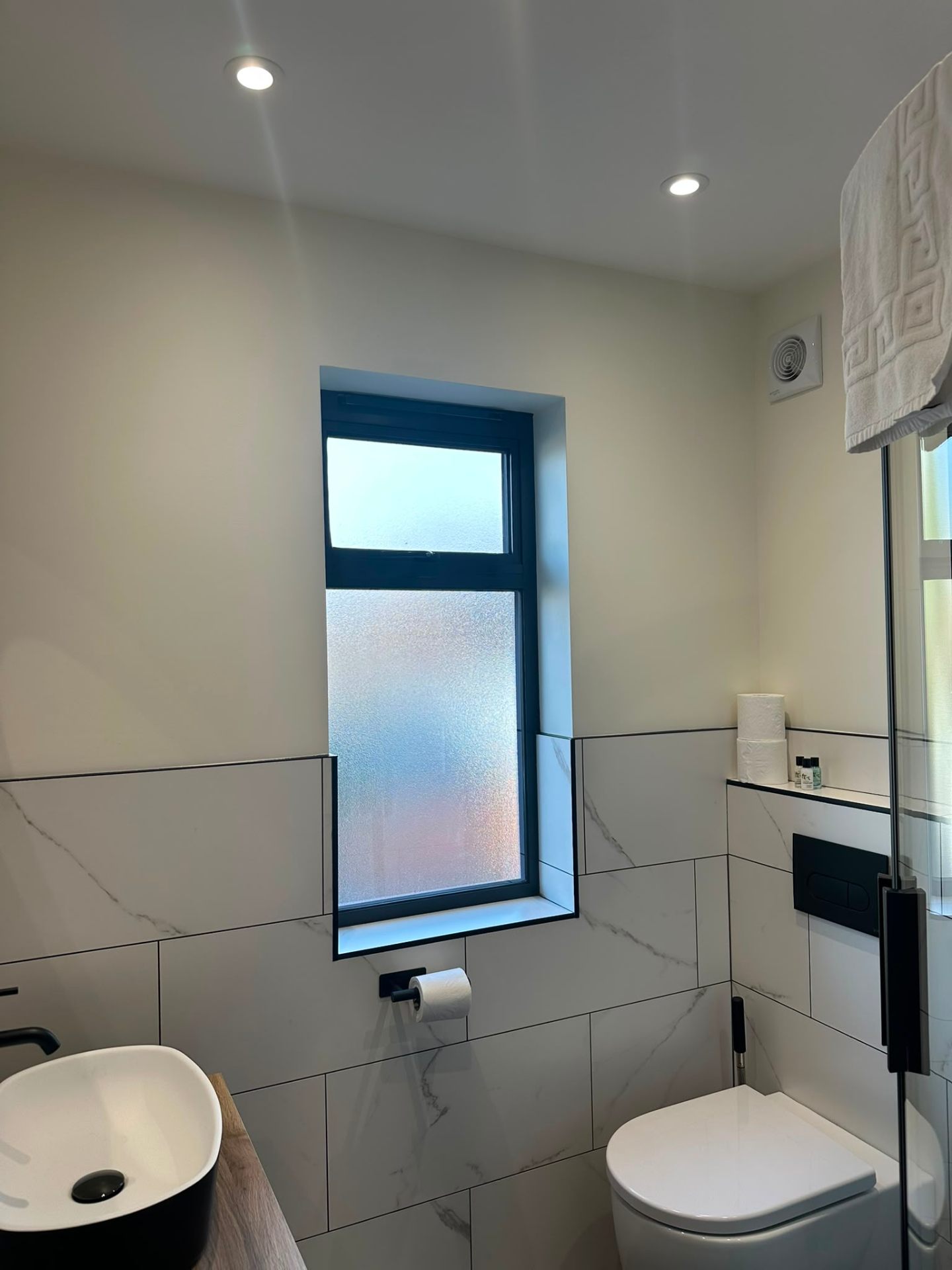 Ensuite bathroom with recessed downlights above marble tiling — domestic bathroom lighting by D.P.L Electrical Services