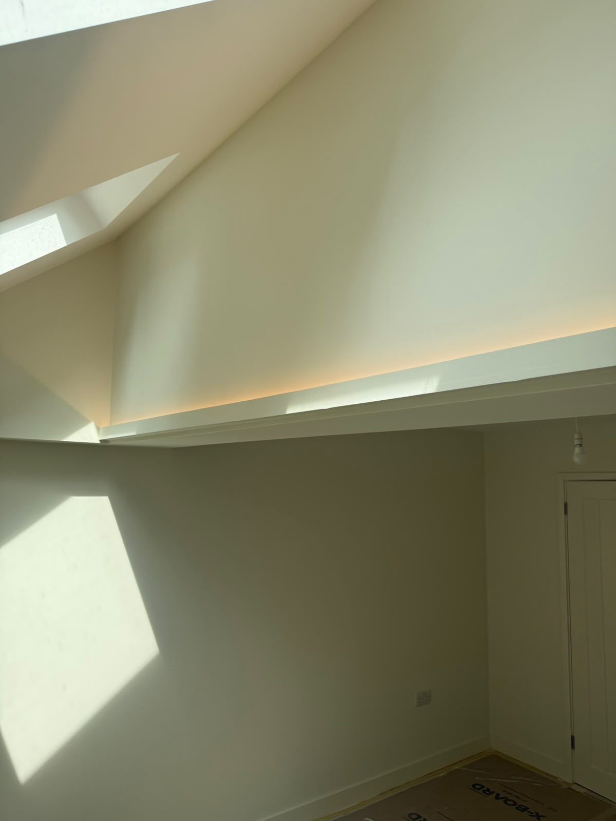 Vaulted ceiling with warm-white linear LED strip lighting above bi-fold glazing — feature lighting installation by D.P.L Electrical Services