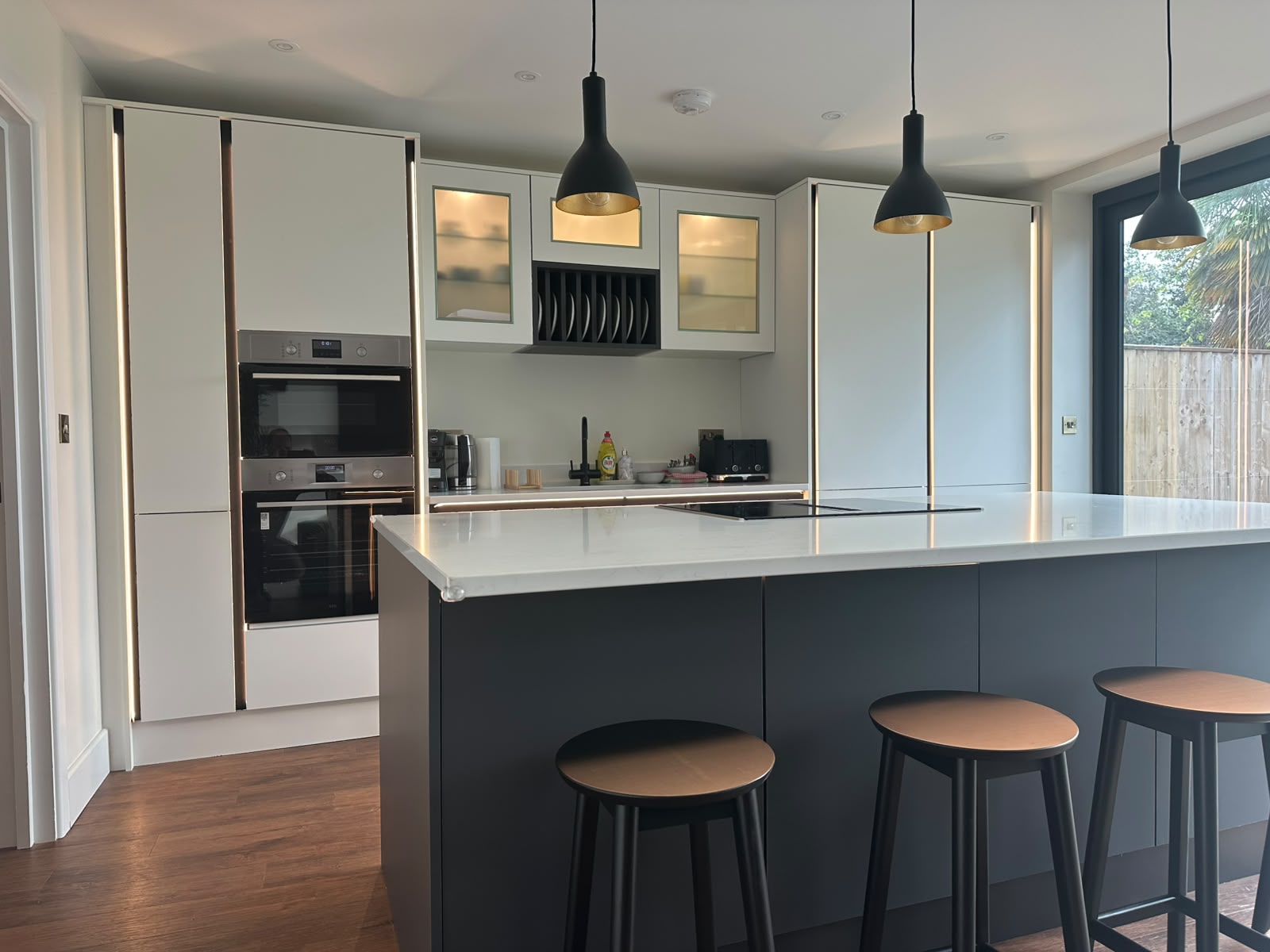 Modern kitchen with black dome pendants over the island and recessed downlights — domestic kitchen lighting by D.P.L Electrical Services