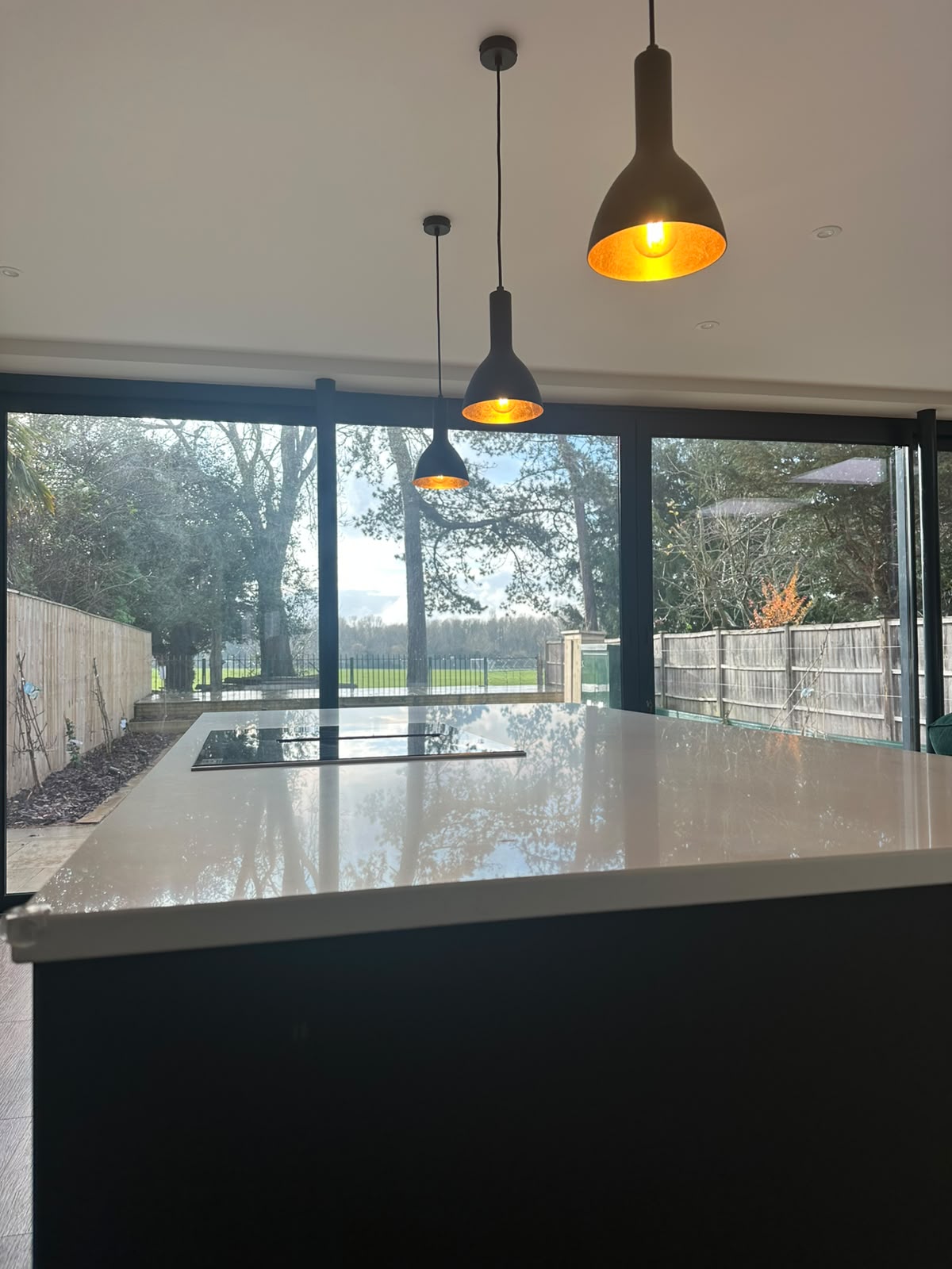 Kitchen island with matched black pendant lighting and downlights — domestic kitchen electrical installation by D.P.L Electrical Services
