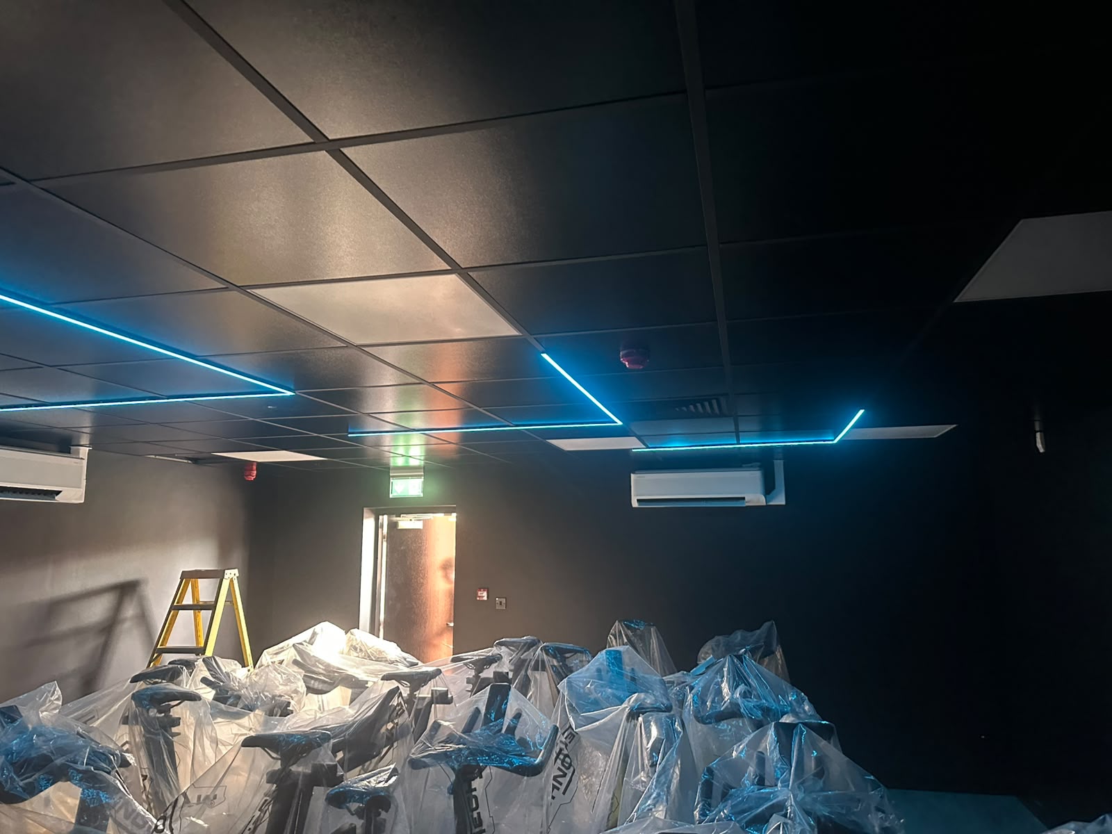 Commercial gym with cyan LED linear lighting scene — commercial lighting fit-out by D.P.L Electrical Services