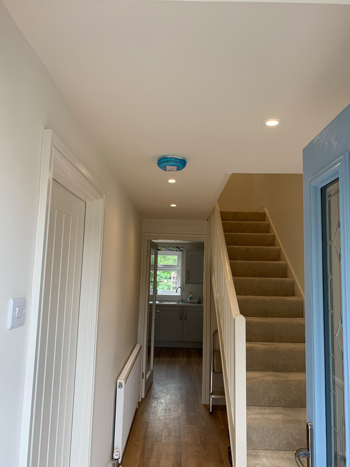 Reception hallway with recessed floor uplights washing a marble column — luxury lighting installation by D.P.L Electrical Services