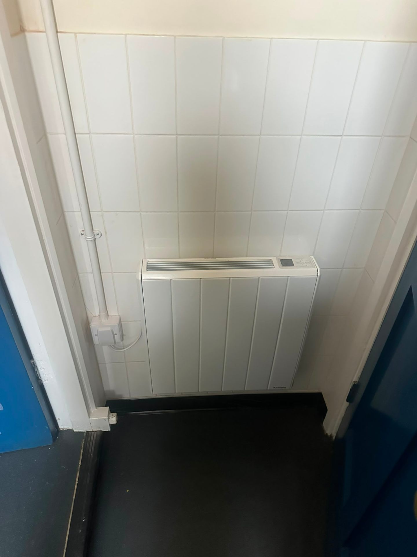 Wall-mounted electric storage heater freshly installed in a tiled utility area — electrical maintenance and heating work by D.P.L Electrical Services in Oxfordshire