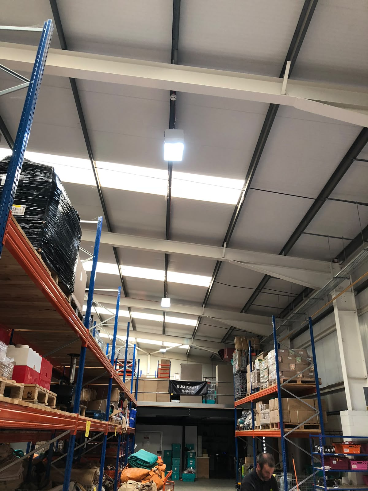 Warehouse ceiling with new LED linear lighting rows and containment installed to a steel deck — commercial lighting installation by D.P.L Electrical Services