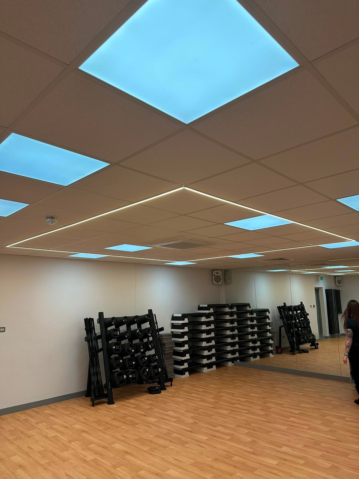 Blue-sky illuminated ceiling panels in a commercial gym studio — commercial lighting installation by D.P.L Electrical Services