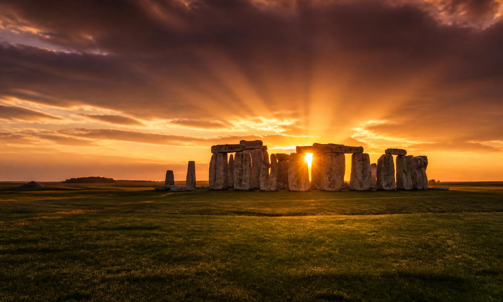 Stonehenge stone circle silhouetted against a golden sunburst on Salisbury Plain — Wiltshire electrical services area covered by D.P.L Electrical Services